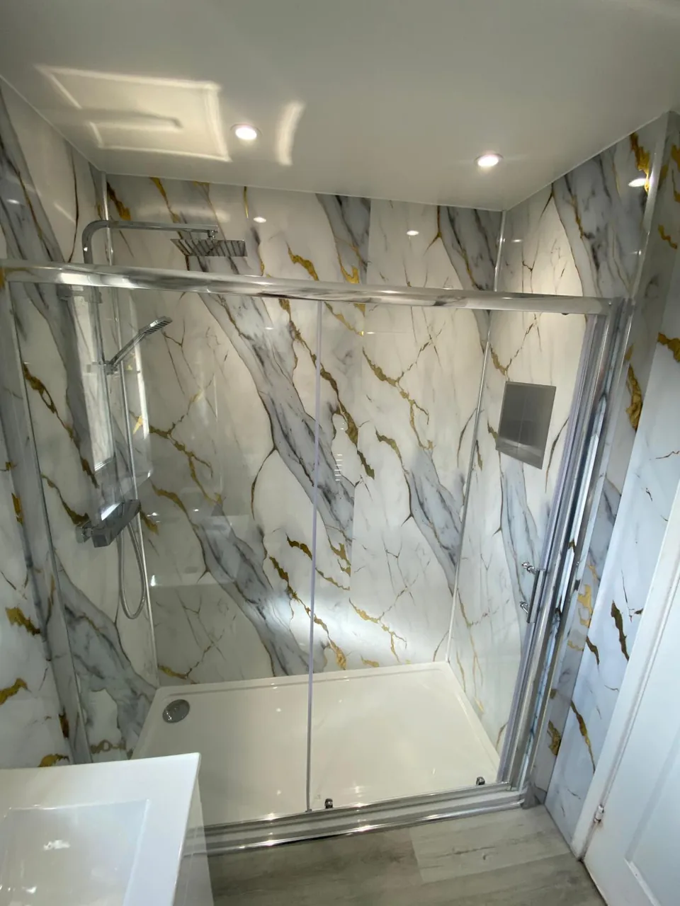 Shower enclosure and gold-veined marble-effect wall panels