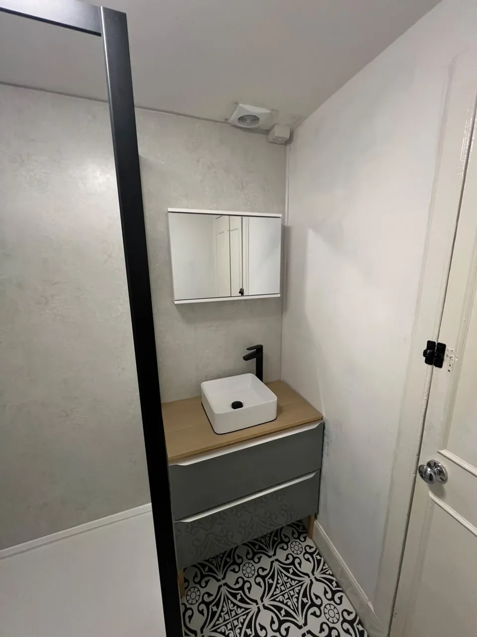Countertop basin on a grey vanity with wood-effect top